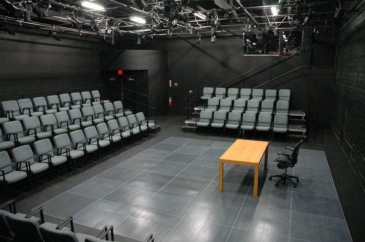 an empty auditorium with rows of chairs and a table