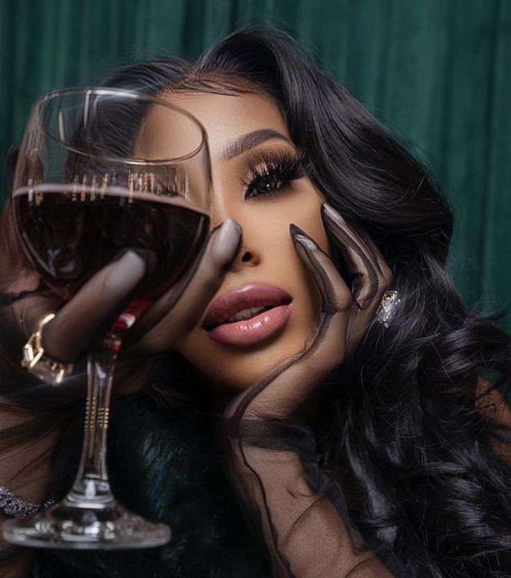 a woman holding a glass of wine in front of her face