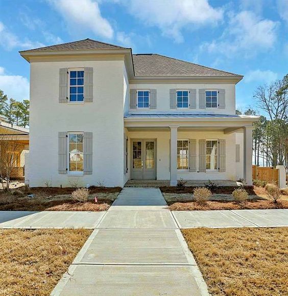 a white two story house with lots of windows