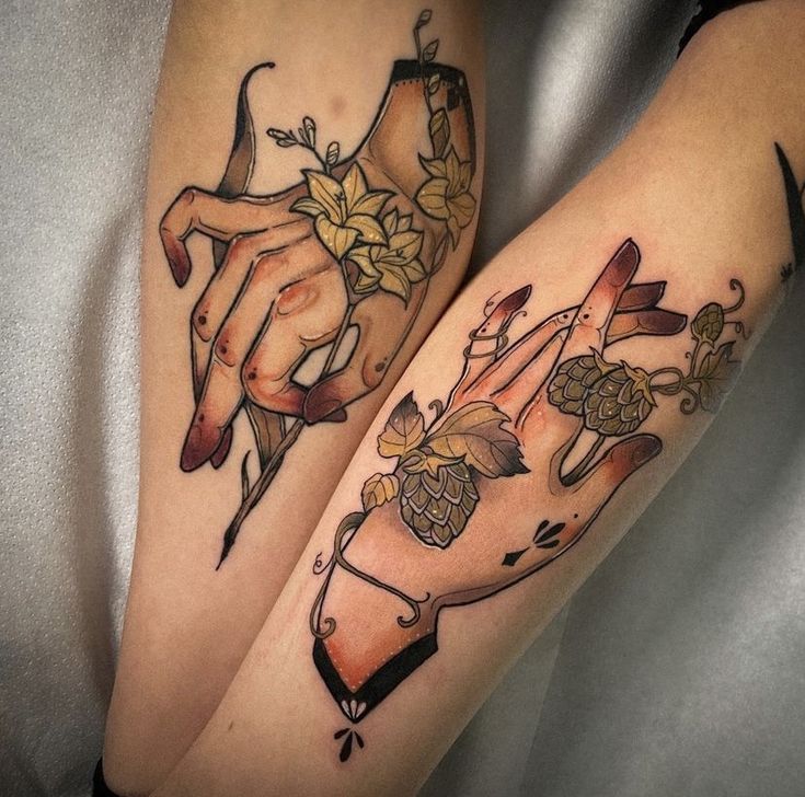 two legs with tattoos on them that have flowers and hands holding wine glasses in the middle