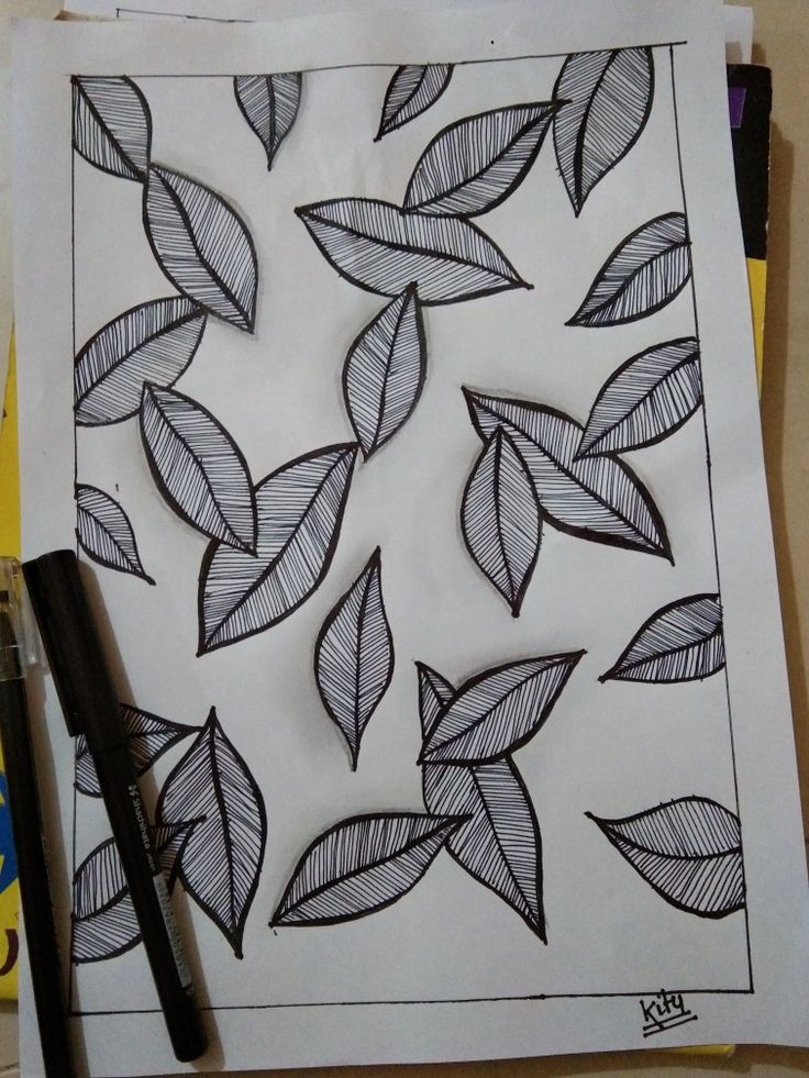 a piece of paper with leaves drawn on it next to a marker and some pens