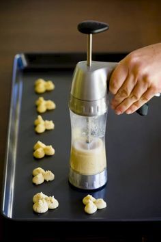 someone is using a food processor to make macaroni florets on a tray