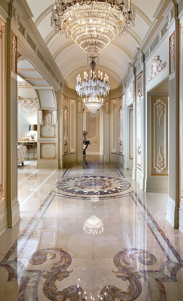 an ornate hallway with chandelier and marble flooring in a palace style building