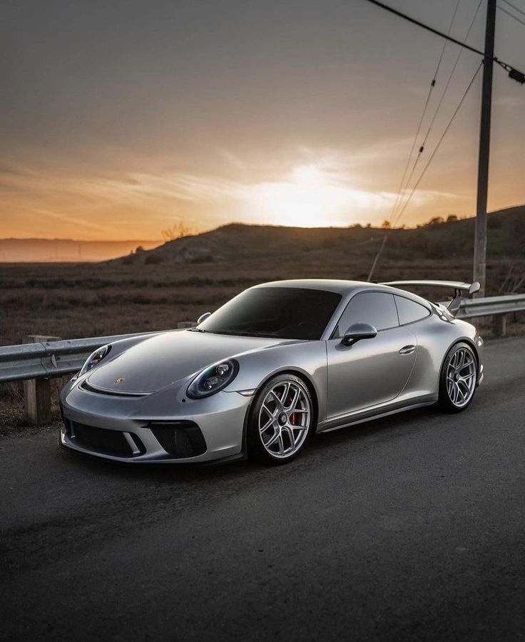 a silver sports car driving down the road