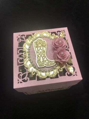 a pink and gold box with some flowers on it