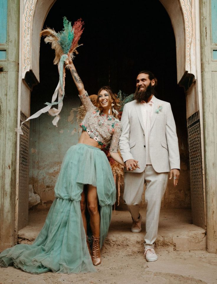 a man and woman are walking out of an archway