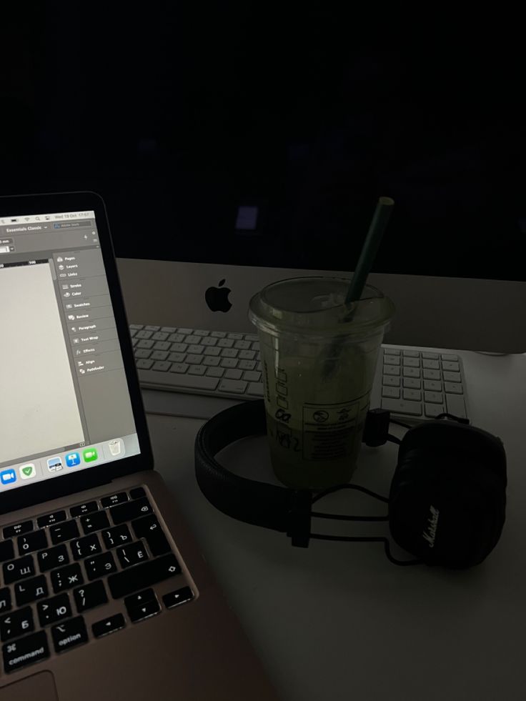 an open laptop computer sitting on top of a desk next to a cup of coffee