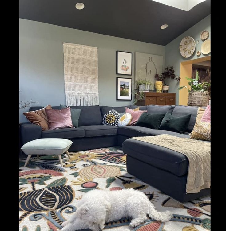 a living room filled with furniture and a white dog laying on the floor next to it