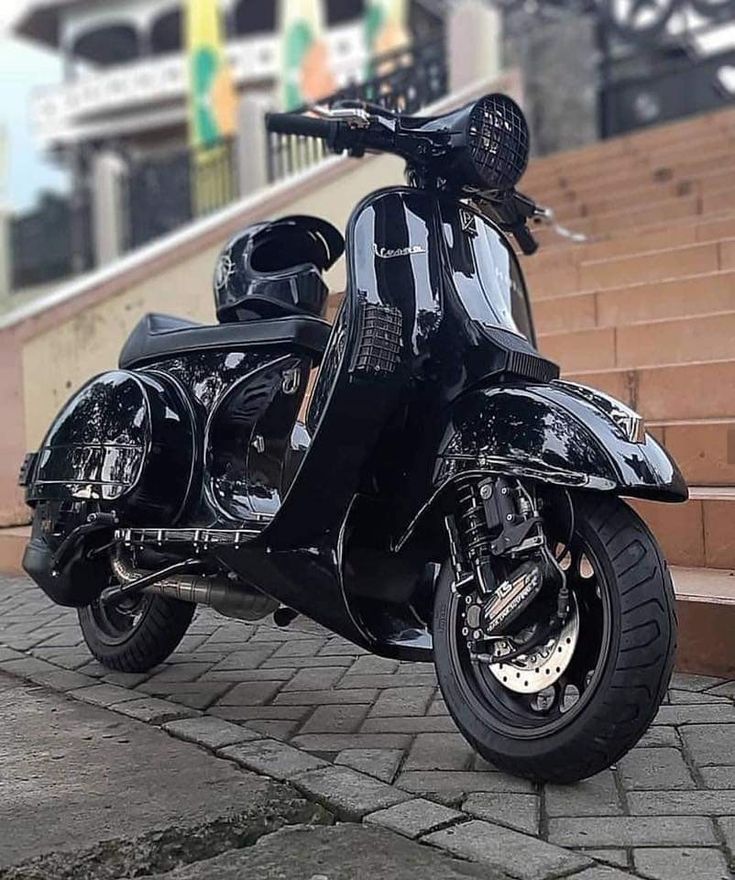 a black scooter parked in front of some steps