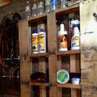 a wooden shelf filled with lots of different types of cleaning products on top of it