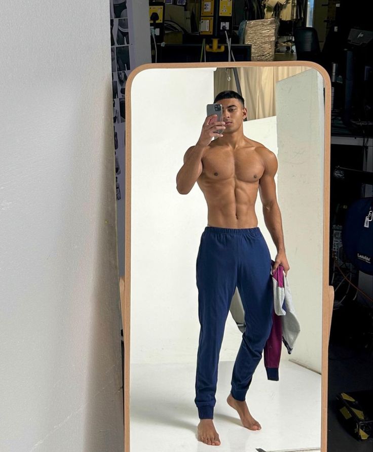 a man standing in front of a mirror taking a selfie with his cell phone