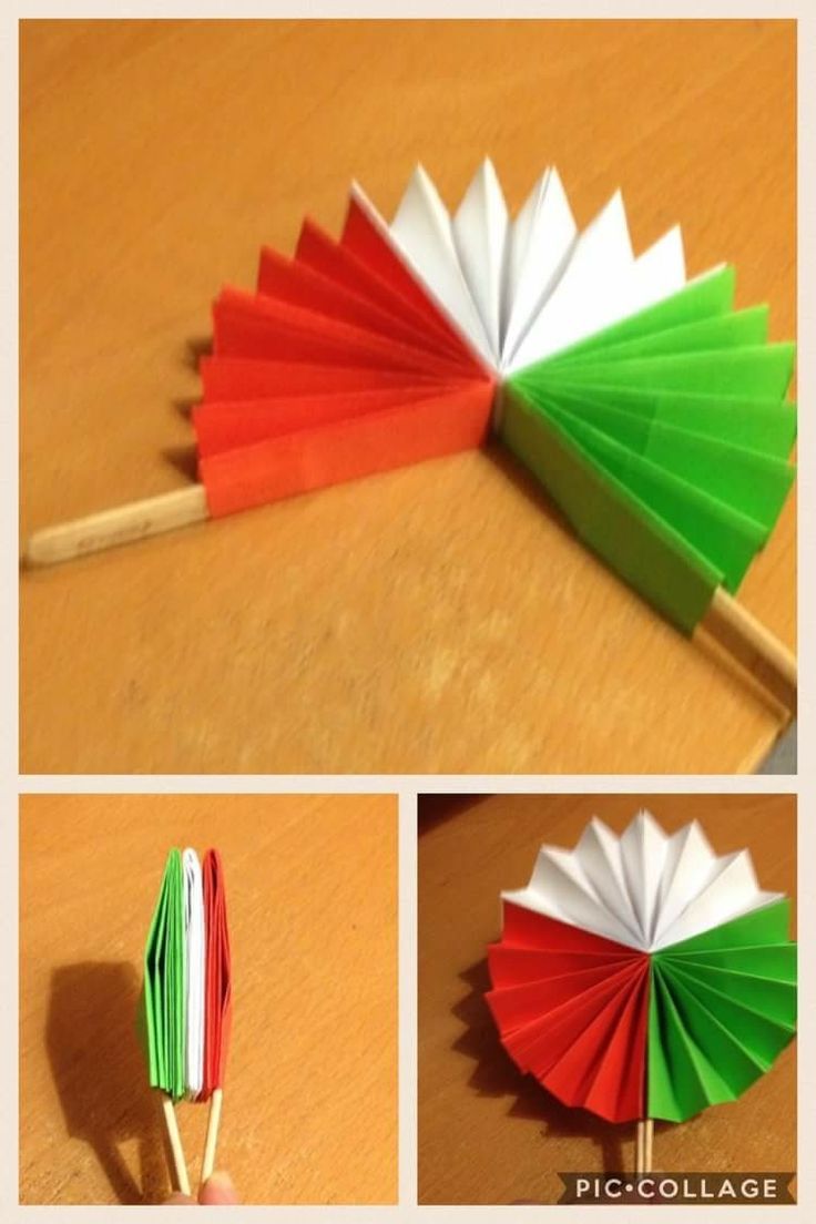 four different colored paper umbrellas sitting on top of a wooden table next to each other