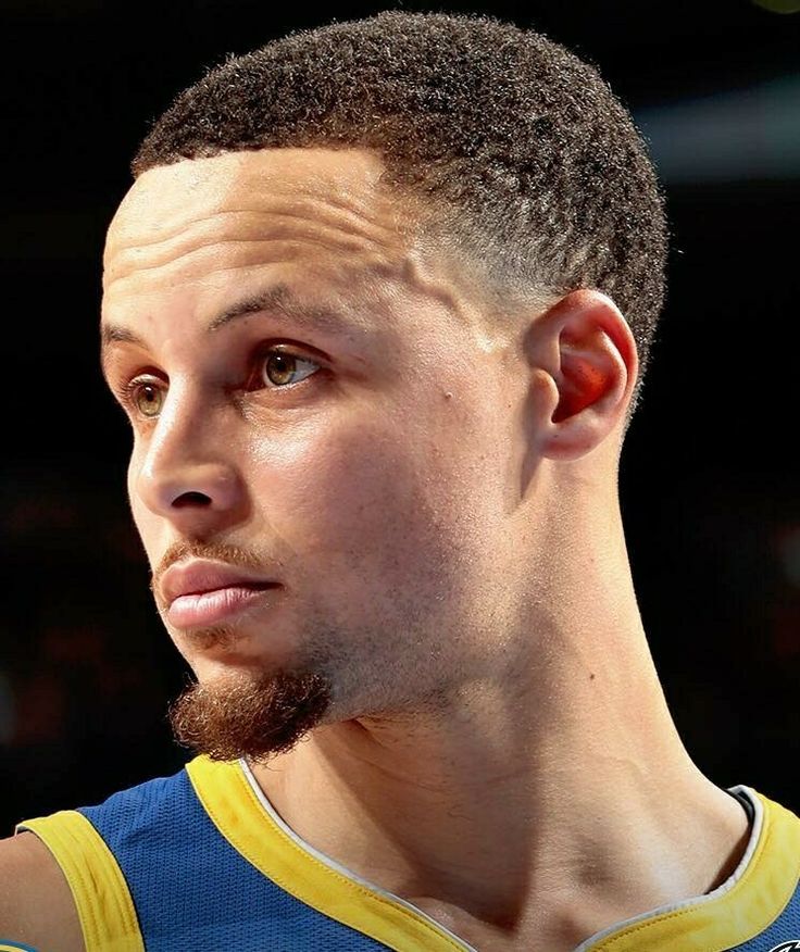 a close up of a basketball player wearing a blue and yellow uniform with his head tilted to the side