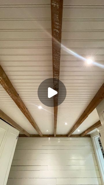 the inside of a room with white walls and wood beams