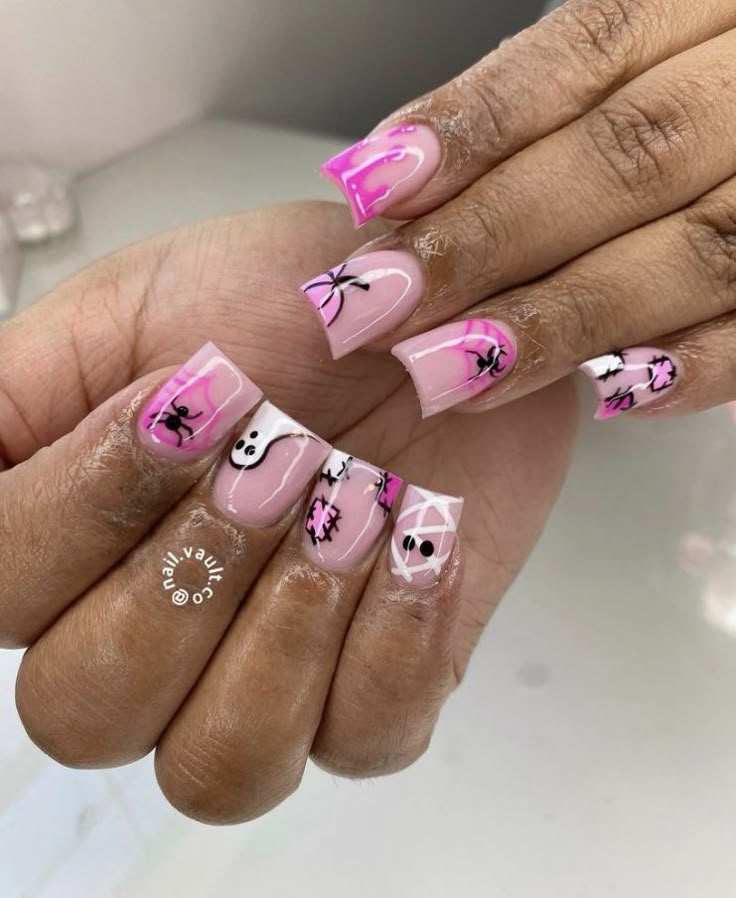 a woman's hands with pink and white nail designs