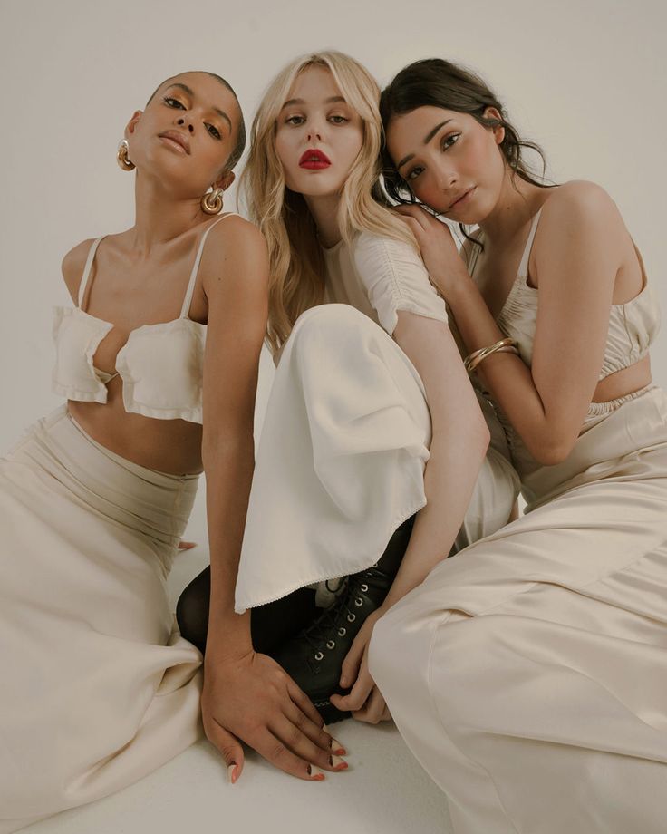 three beautiful women sitting next to each other in front of a white background with the word ww on it