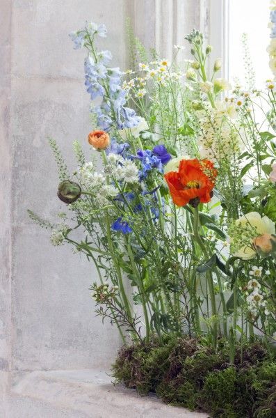 an arrangement of flowers in front of a window