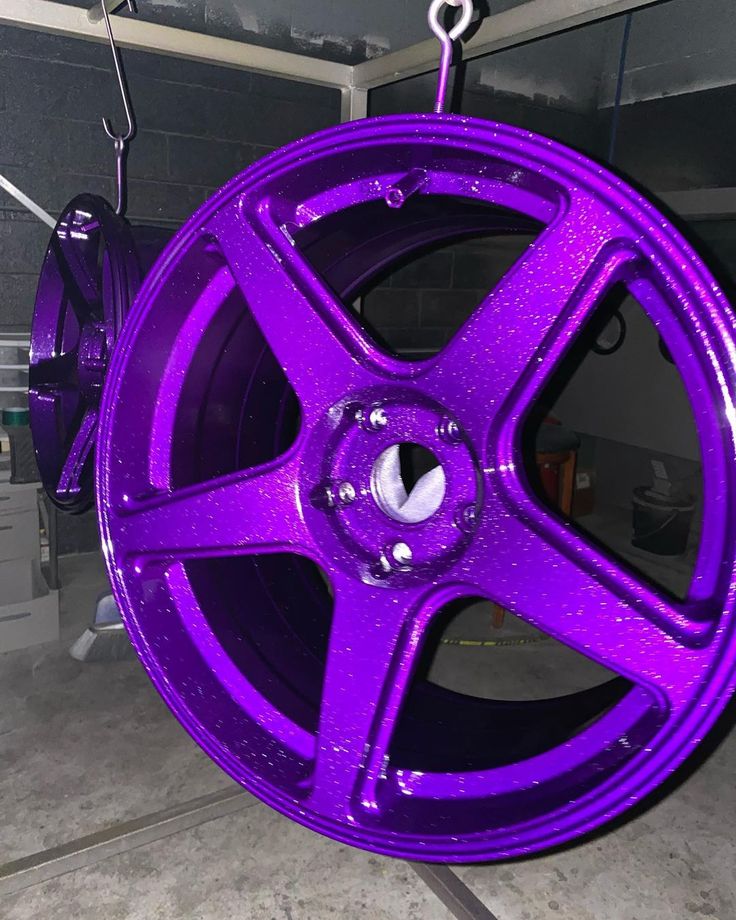 a purple wheel hanging from a hook in a garage