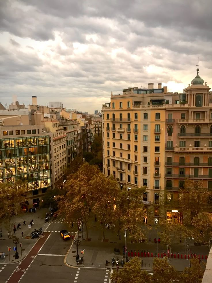 an aerial view of a city with tall buildings and cars on the street in front of it