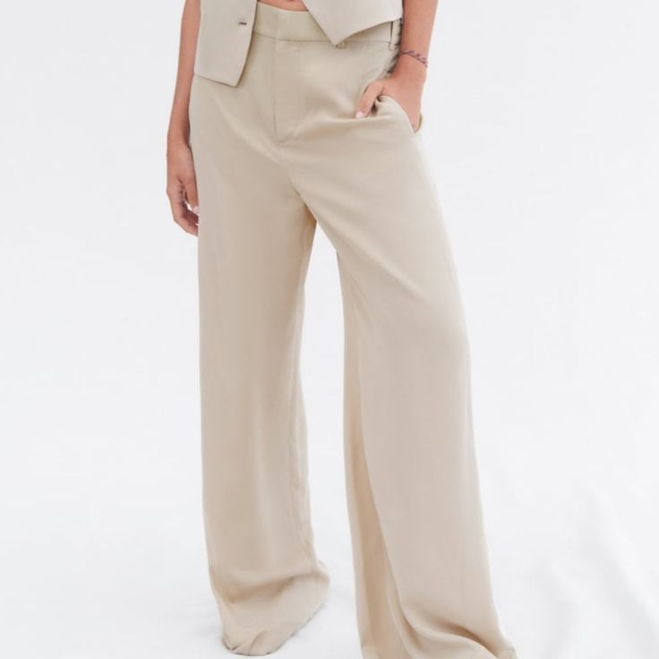 Side Pockets And False Back Welt Pocket. Wide Leg. Front Zip, Button, And Metal Hook Closure. Taupe Brown | Wide Leg Pantsuit With Button Closure For Work, Chic Straight Leg Pants With Buttons, Beige Summer Pants With Buttons, Summer Beige Pants With Buttons, Tailored Wide Leg Pants With Button Closure, Chic Tailored Dress Pants With Button Closure, Tailored Wide Leg Bottoms With Buttons, Chic Wide Leg Pants With Buttons For Work, Wide-leg Pants With Button Closure For Office