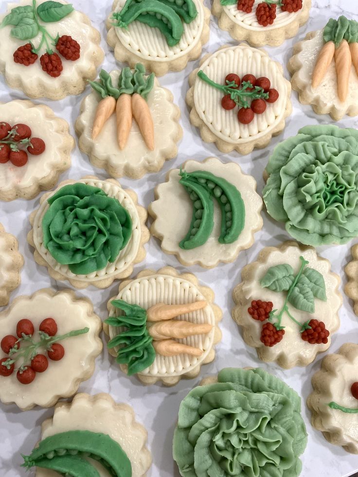 decorated cookies are arranged in the shape of flowers and vegetables on a sheet of paper