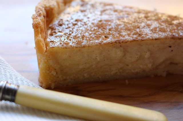 a piece of pie sitting on top of a wooden cutting board next to a pen