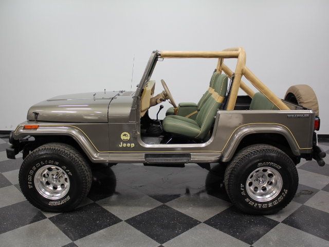 an old jeep is parked on a checkered floor