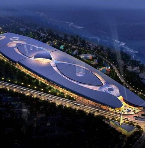 an aerial view of a stadium at night with lights on the roof and large circular structure