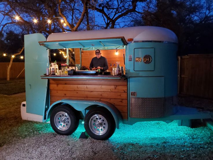 a man standing in front of a food truck with lights on it's side