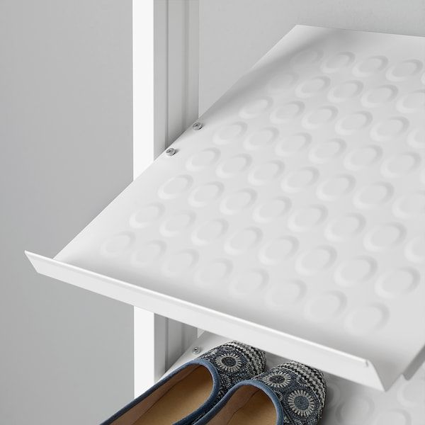 a pair of blue shoes sitting on top of a white shelf next to a door