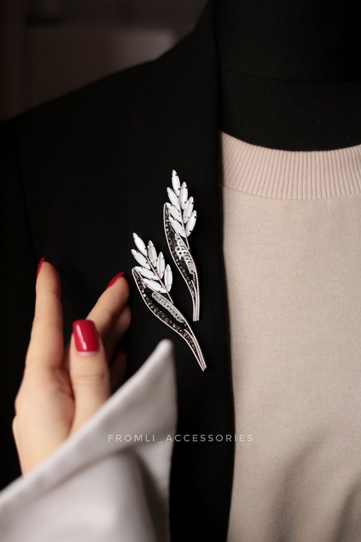 a close up of a person wearing a suit and holding onto a lapel pin