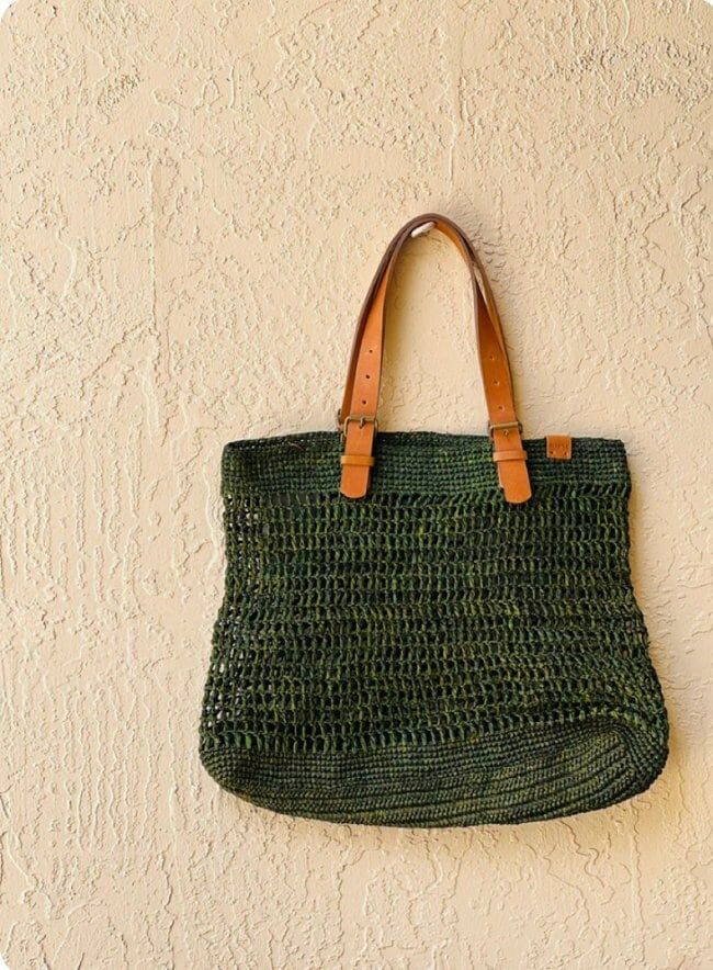 These gorgeous handwoven totes are designed and produced in Cape Town, South Africa.  Each piece is composed from sun dried raffia and leather. Please note some will be a deep moss green while others may appear more emerald- as they are all hand dyed variations may occur Eco-friendly Crochet Bag With Woven Leather, Eco-friendly Crochet Jute Bag With Woven Leather, Eco-friendly Crochet Bag With Woven Leather Details, Handwoven Green Crochet Beach Bag, Eco-friendly Jute Crochet Bag With Woven Leather, Casual Green Woven Leather Shoulder Bag, Natural Leather Handwoven Crochet Bag, Bohemian Everyday Woven Leather Straw Bag, Everyday Bohemian Straw Bag With Woven Leather