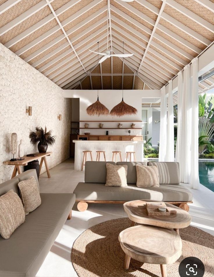 a living room filled with furniture next to a swimming pool