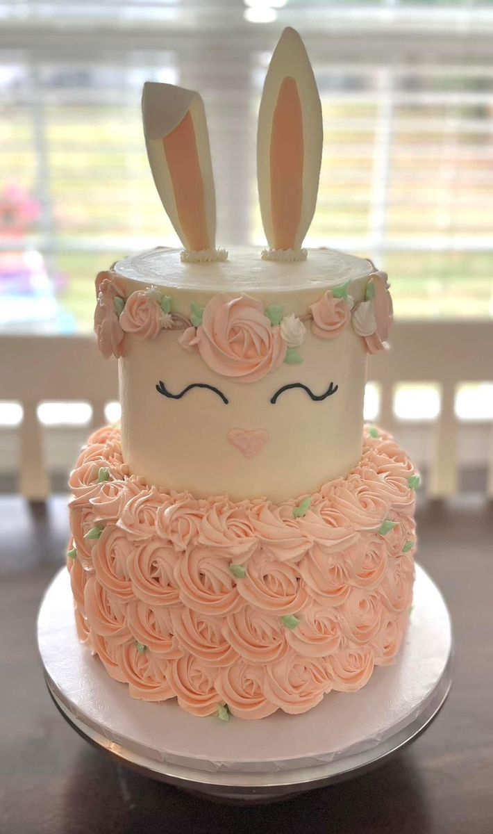 a cake with pink frosting and bunny ears on top