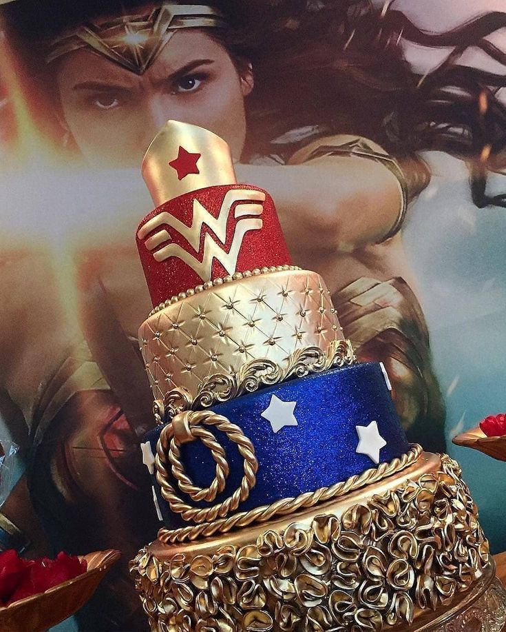 there is a cake that has wonder woman on it and gold decorations around the top