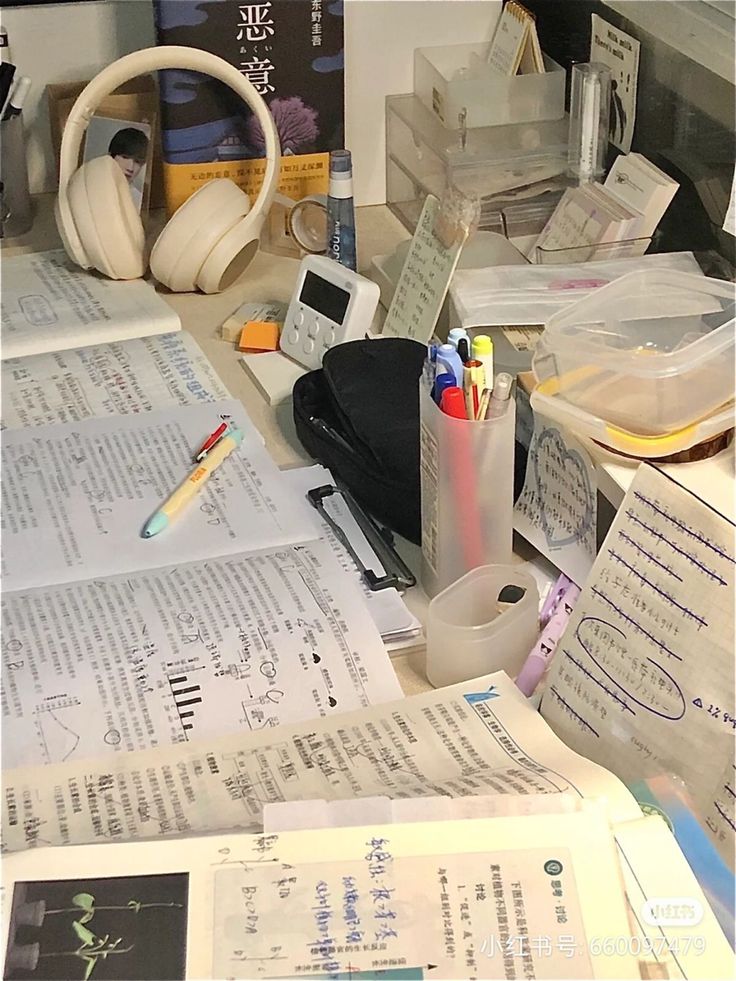 there are many papers on the desk with headphones and pencils in each one