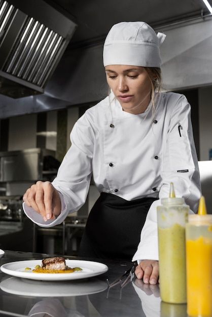 a woman in a chef's hat is preparing food on a plate at the counter