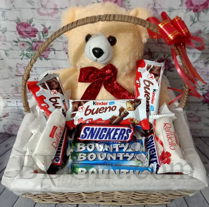 a teddy bear sitting in a basket filled with candy