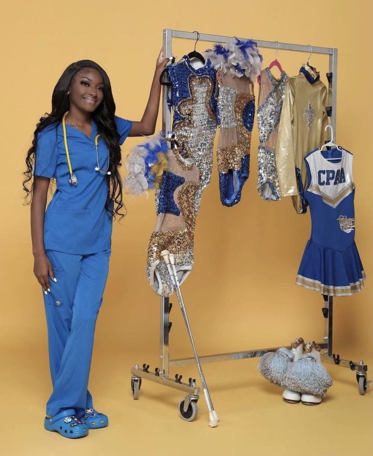 a woman in scrubs standing next to a rack of clothes