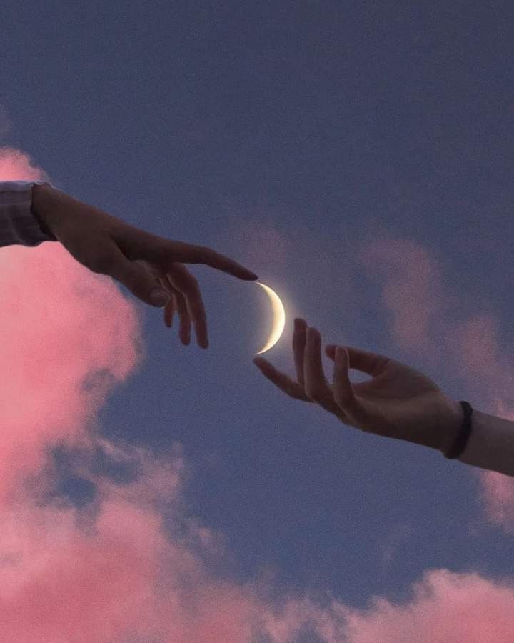 two hands reaching out towards each other with the moon in the sky and clouds behind them