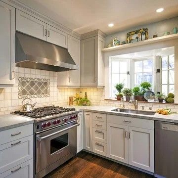 a kitchen with white cabinets and stainless steel stove top oven, dishwasher, and sink