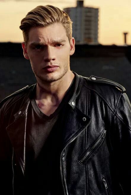 a man in a leather jacket looking at the camera