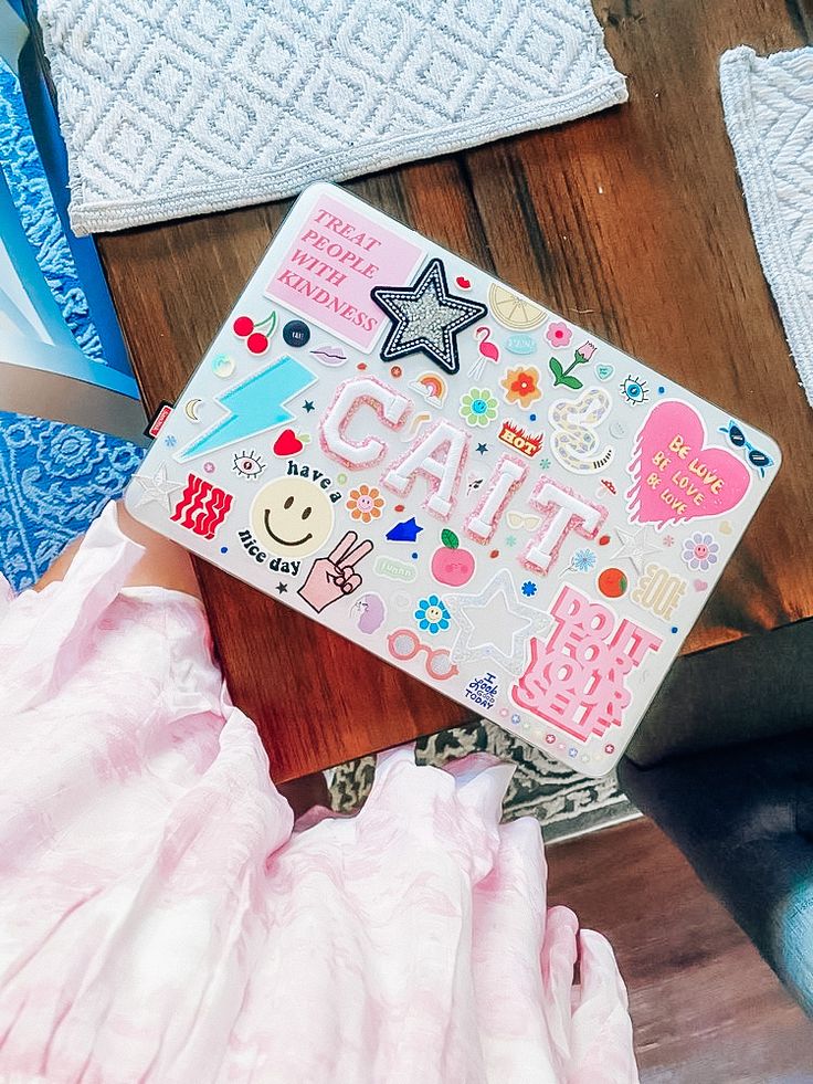 a wooden table topped with lots of different types of stickers and paper crafts on top of it