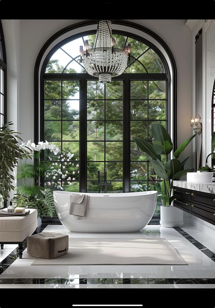 a bathtub in front of a large window with potted plants