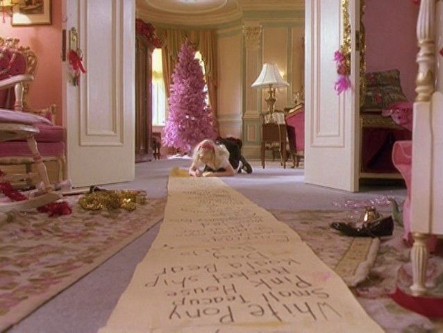 a room with pink walls and carpeted flooring, decorated in gold trimmings