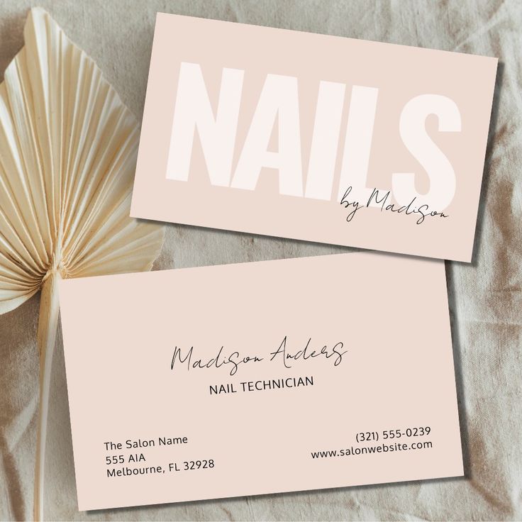 two business cards with the word nails on them next to an origami fan