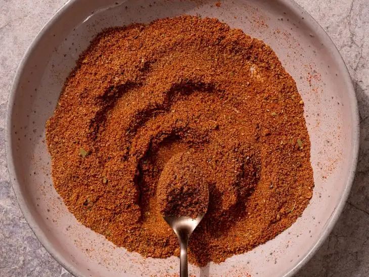 a white bowl filled with spices on top of a table