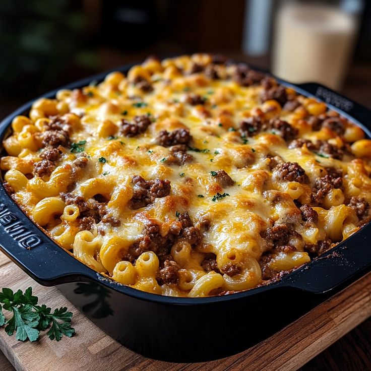 a casserole dish with meat and cheese in it on a wooden cutting board