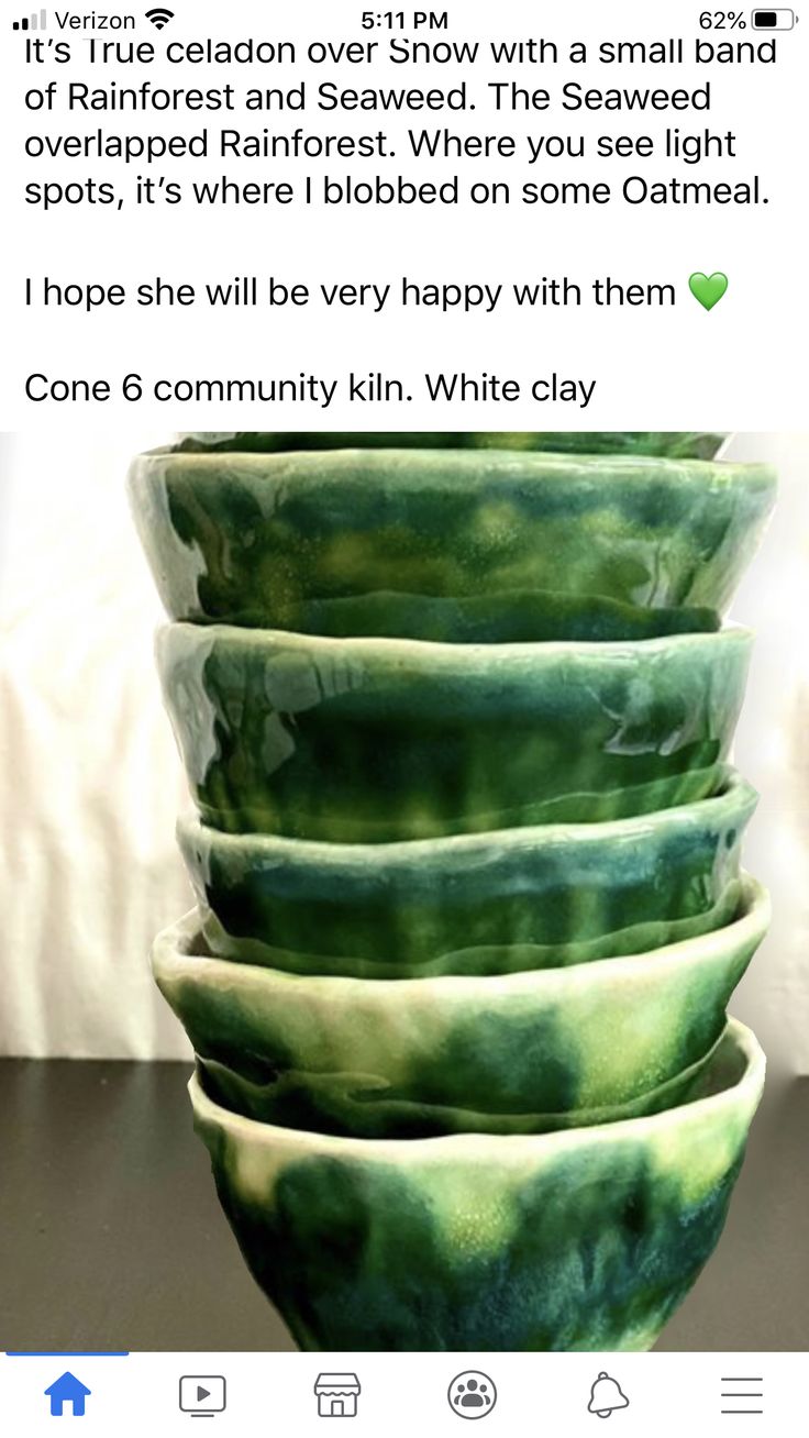 a stack of green and white bowls sitting on top of a table next to each other