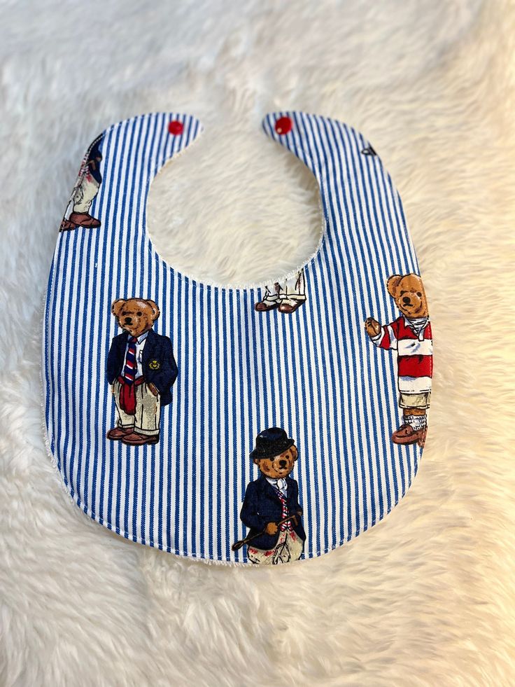 Who doesn't want a baby bib made with the iconic Ralph Lauren polo bear fabric?  This bib features the bears  on a blue and white striped background, is 100% cotton, backed with white absorbent 100% cotton terry cloth, and closes with a red snap. Perfect for baby shower gifts, first birthdays, or have in the everyday rotation!  Want a little more?  How about a matching burp cloth?  This one is ergonomically designed for the most comfort and coverage.  One side is contoured for closeness to the n Ralph Lauren Polo Bear, Bear Fabric, Wanting A Baby, Fabric Tote Bags, Small Case, Blue Birthday, Polo Bear, Striped Background, Burp Cloth